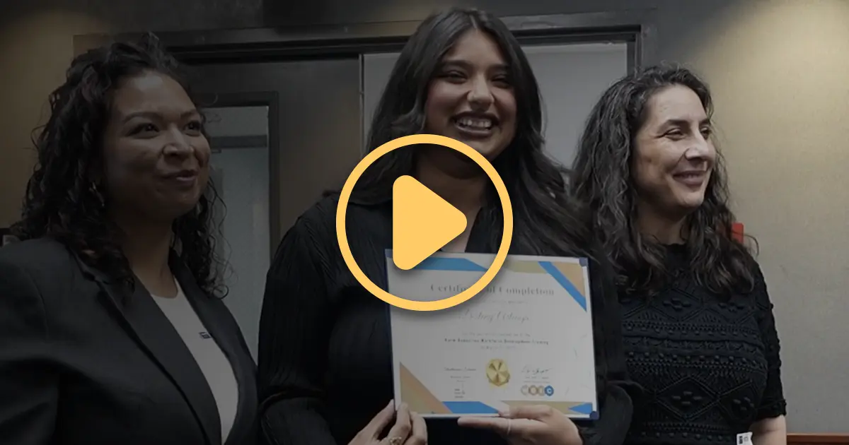 A graduate from the newly launched Worker Education and Resource Center Program smiles as she receives her certificate.