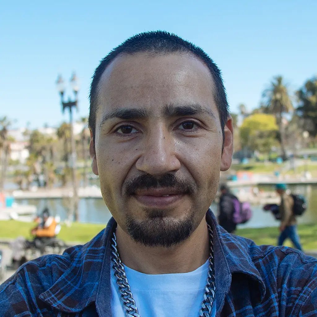 A close-up portrait of a successful program participant smiling at camera.