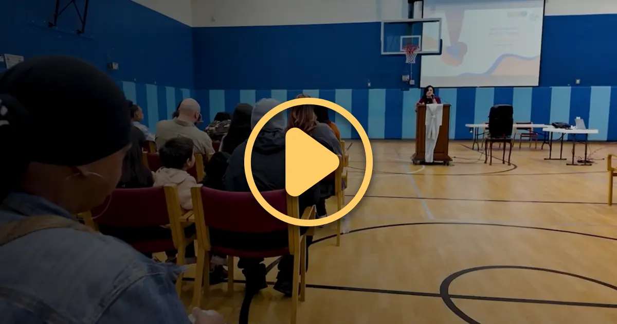 A Harm Reduction worker talks from a lectern during a graduation ceremony for Harm Reduction workers.